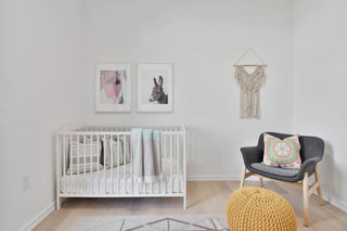 minimalist baby nursery with crib, chair, and wall decor