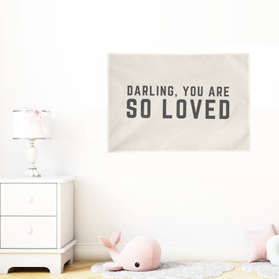 white nursery with "darling you are so loved" wall flag hung on the wall