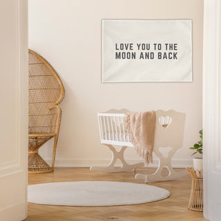 neutral nursery with crib and "love you to the moon and back" wall flag