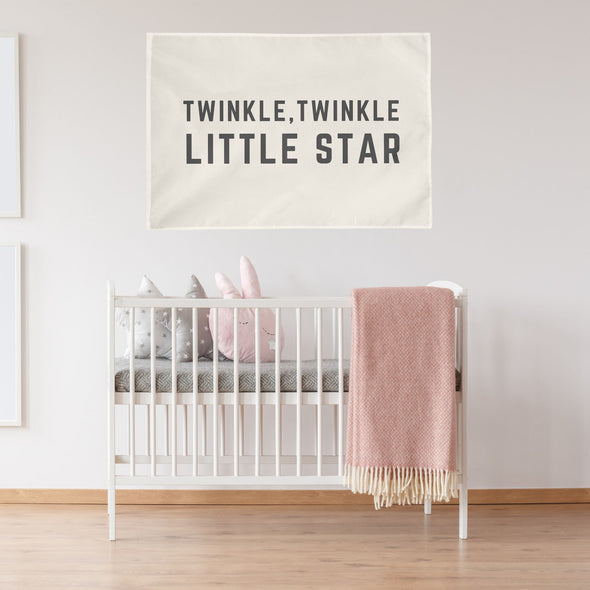 "twinkle twinkle little star" wall flag hanging above a crib in a nursery