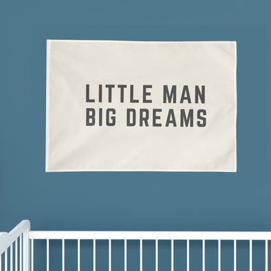 "little man big dreams" wall flag hanging above a crib