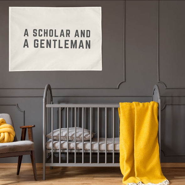 gray and yellow themed nursery with "a scholar and a gentleman" wall flag hanging up above a crib