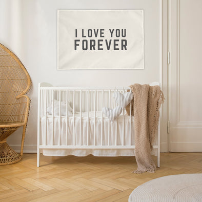 "i love you forever" wall flag hanging in a baby nursery