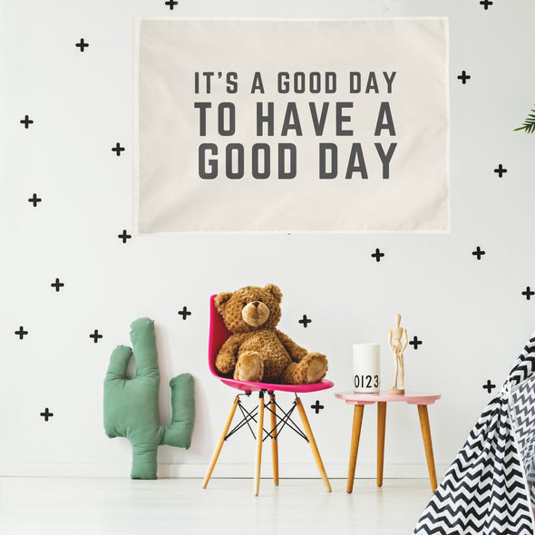 baby nursery with "it's a good day to have a good day" wall flag hanging up above a table and chair