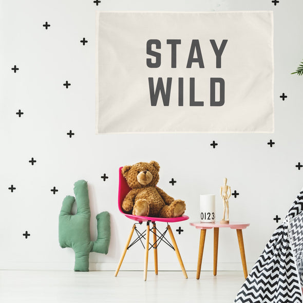 child's room with "stay wild" wall flag hanging up