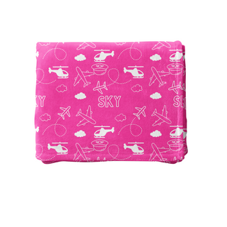 a pink blanket with airplanes and clouds on it