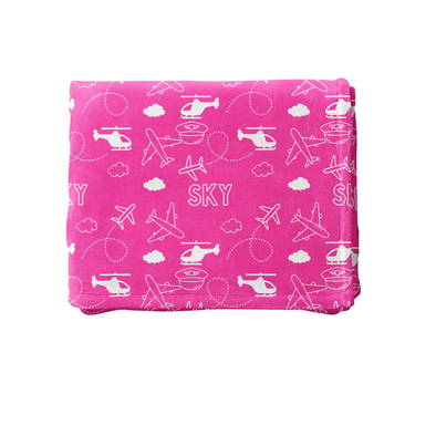 a pink blanket with airplanes and clouds on it