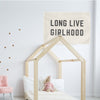 little girl's room with toddler bed, pink chair, and "long live girlhood" wall flag